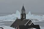 Zion Church, verdadeiro cartão postal de Ilulissat, na Groelândia. Ao fundo, icebergs passam pela costa.